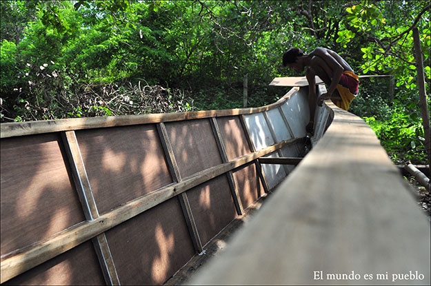 Un hombre está acabando de fabricar su propia barca para salir a pescar